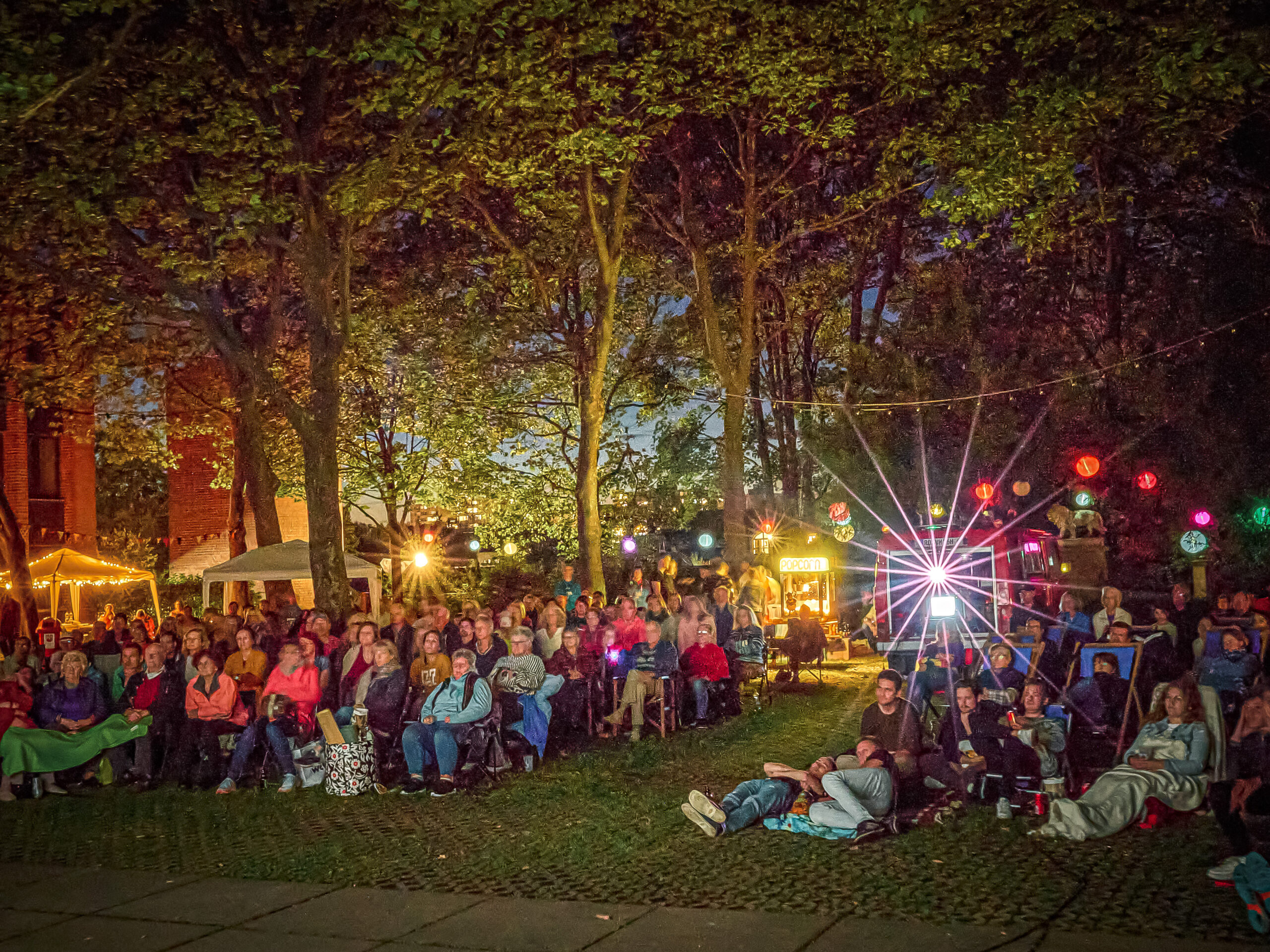 Publikum beim Kino Open Air Event: Der Schloßpark in der Nacht ist bis auf den letzten platz gefüllt und darüber hinaus